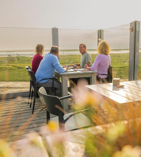 Freunde auf der Dachterrasse eines Pfahlbaurestaurants