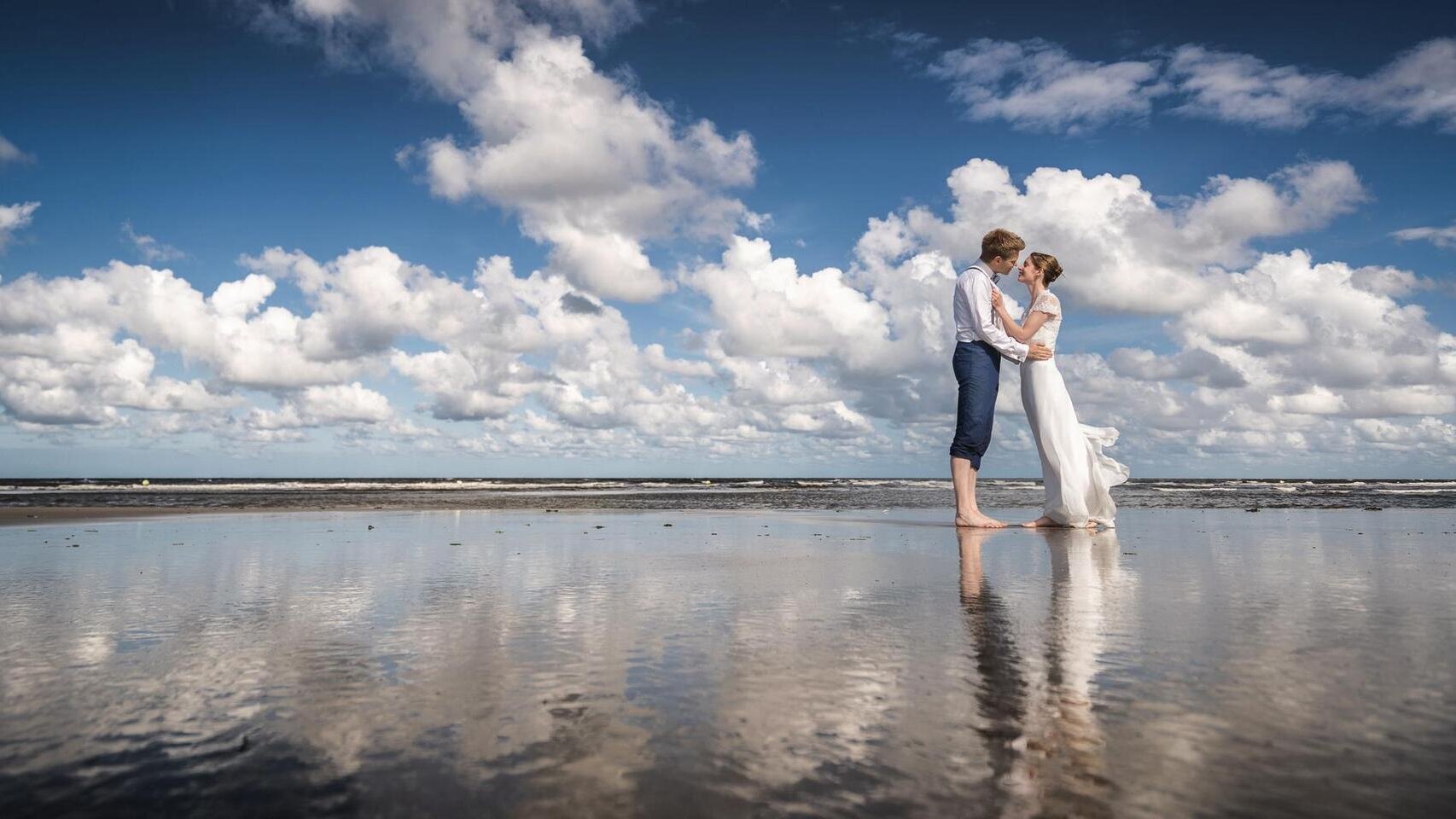 Hochzeitspaar küsst sich am Strand