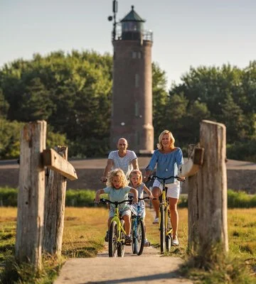 Familie beim Fahrradfahren vor dem Böhler Leuchtturm