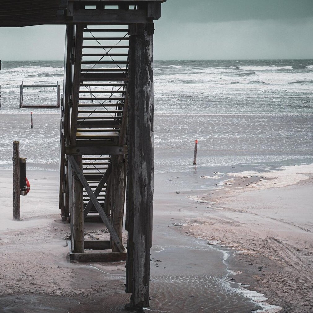 Treppe eines Pfahlbaus mit Blick auf Sturmflut