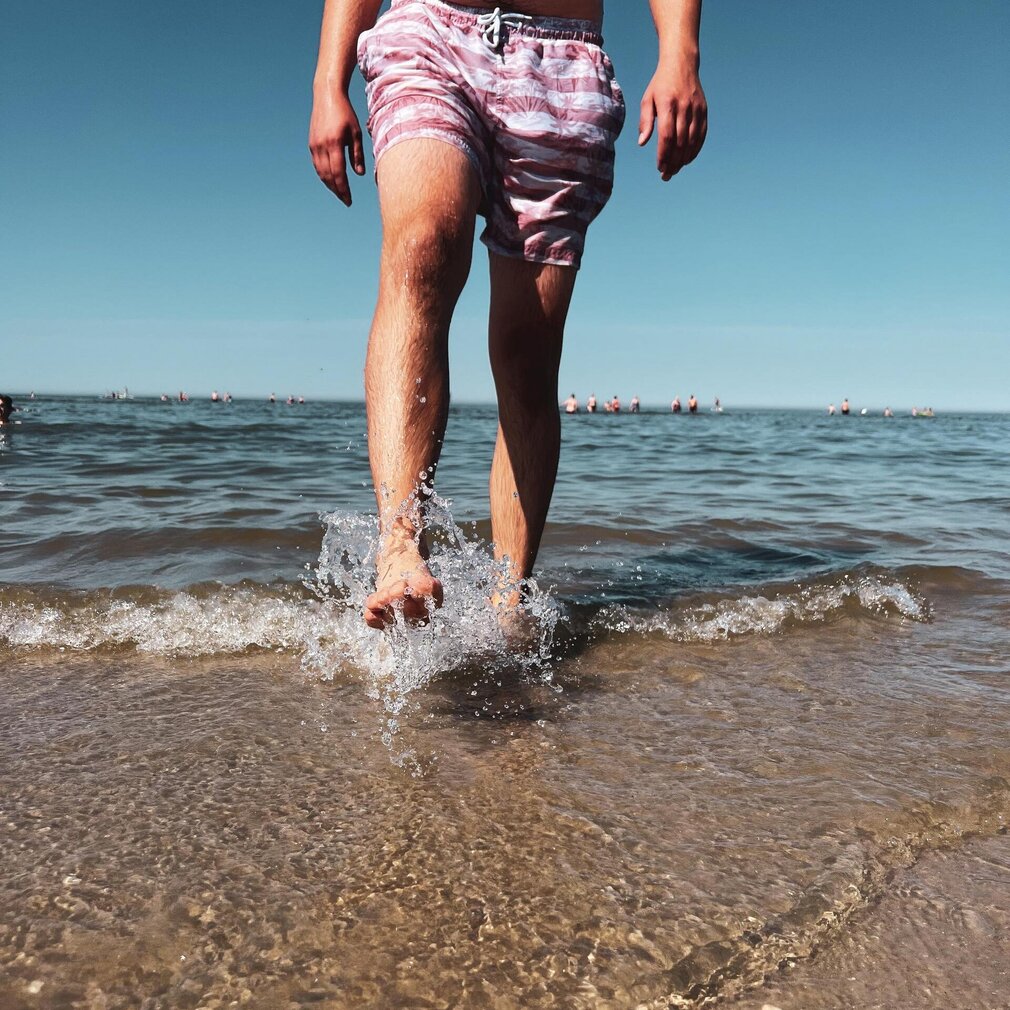 (c)TZ-SPO_Strand_Ording_Sommer_baden_Meer_Wasser Mann läuft durch die Wellen am Strand