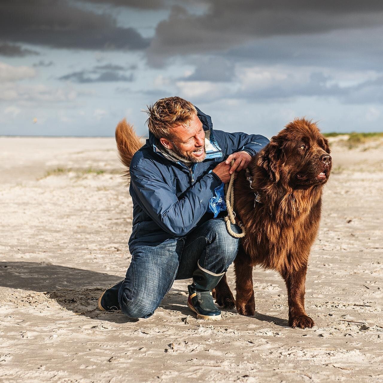 Mann mit Hund am Strand