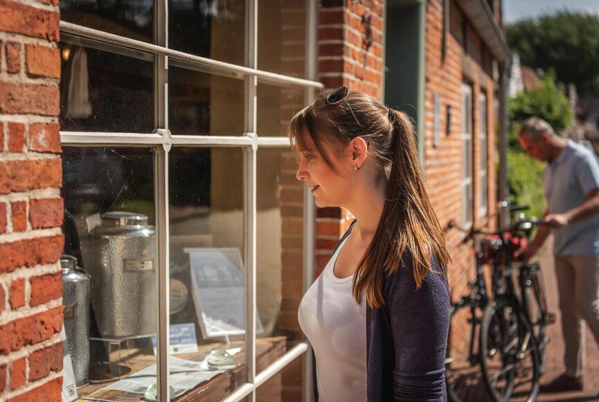 Frau schaut in das Schaufenster vom Haus Peters