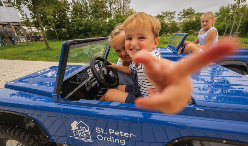 3 Kinder in den Autos der Big-Five-Safari auf der Erlebnispromenade