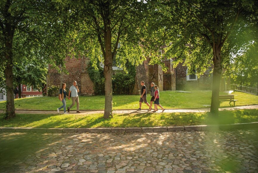 Personen auf dem Gehweg vor der Gardinger Kirche