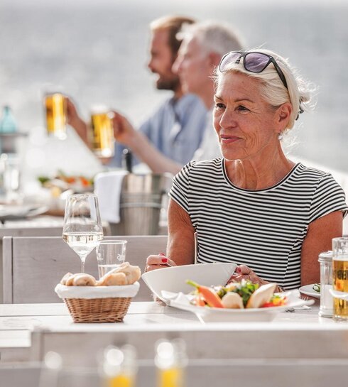 sympathische Dame sitzt an einem gedeckten Tisch