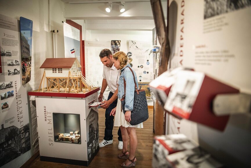 Paar beim Begutachten eines Pfahlbau-Modells im Museum