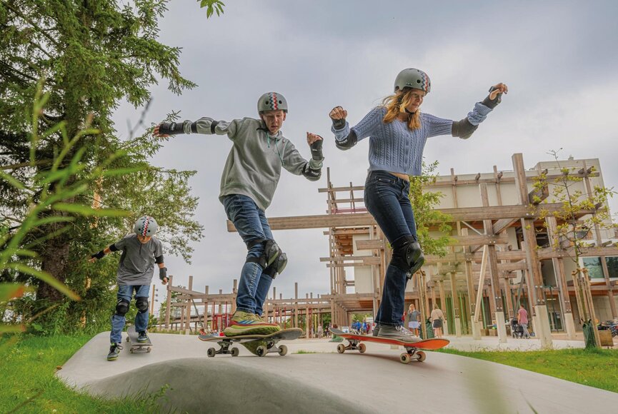 Kinder mit Skateboards auf der Skatebahn