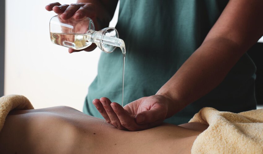 Öl tropft in die Hand für eine Massage 