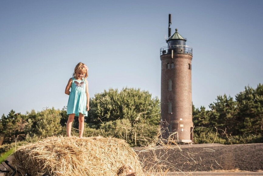 Mädchen auf Heuballen vor Böhler Leuchtturm