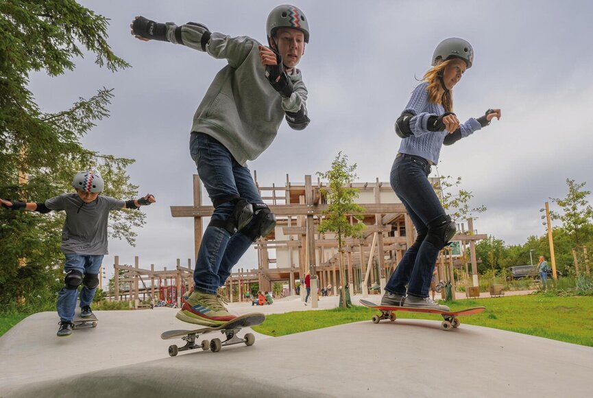 Kinder mit Skateboards auf der Skatebahn