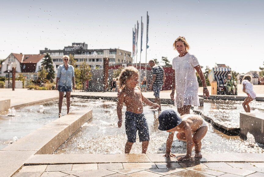 Familie beim Wasserspiel auf der Buhne