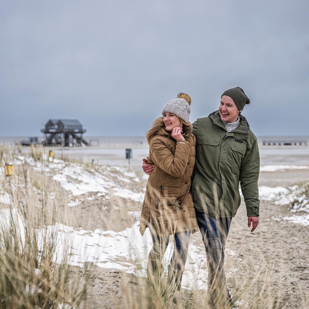 Paar bei einem winterlichen Spaziergang am Ordinger Strand