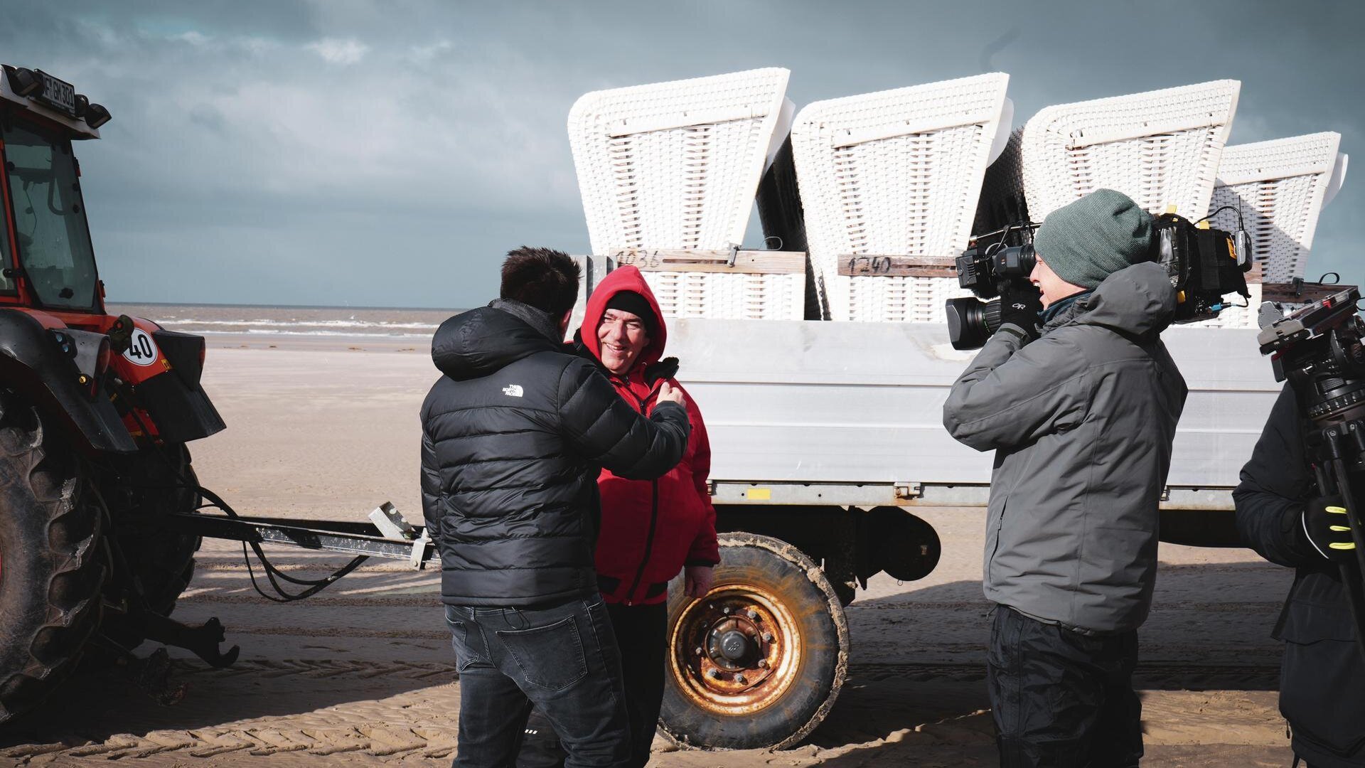 Interview eines Strandmitarbeiters vor einem Anhänger mit Strandkörben