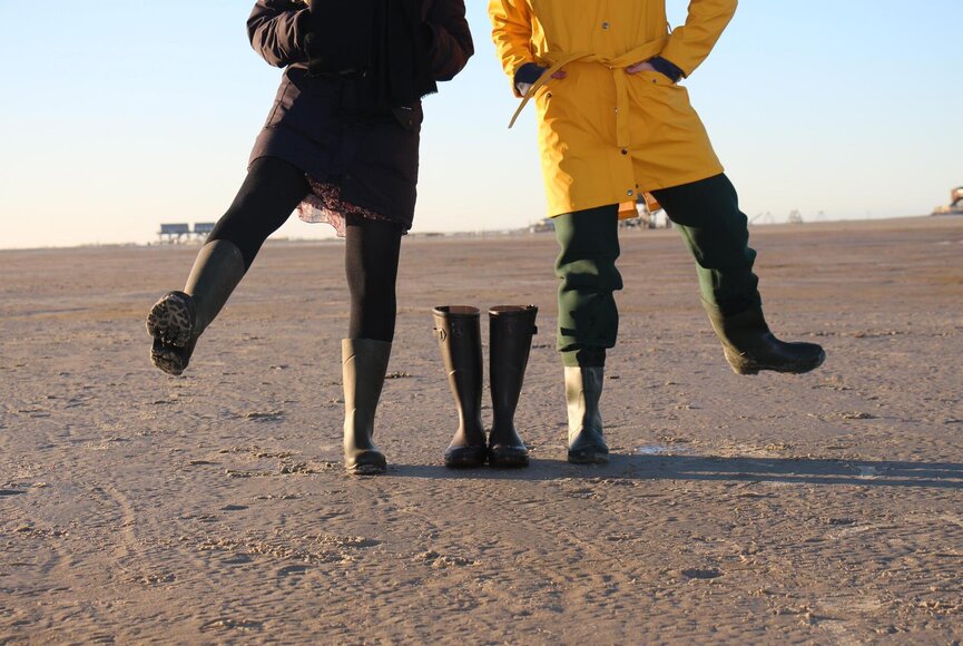 zwei Nordfriesen in typischer Kleidung - Gummistiefel und Regenjacke