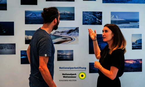 Ein Mann und eine Frau stehen vor einer Fotowand.