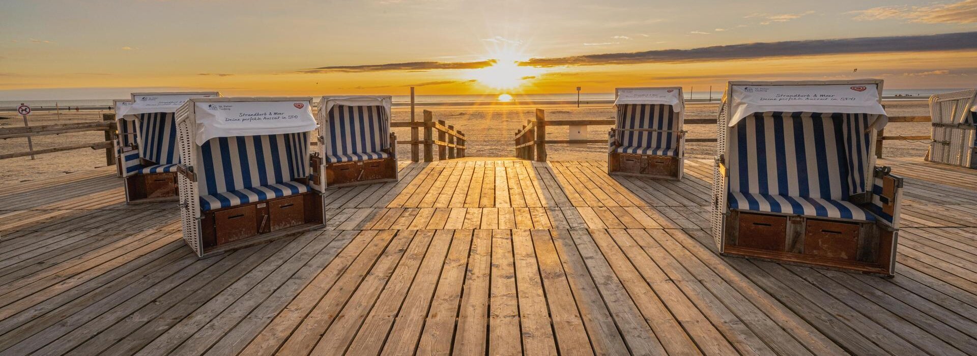Strandkörbe auch einem Podest beim Sonnenuntergang
