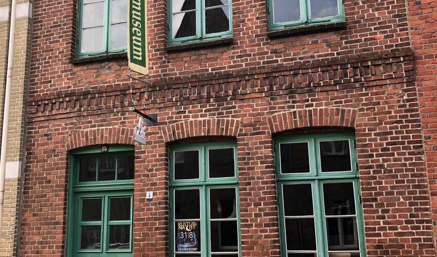 Außenansicht des Tischlereimuseums mit rotem Backstein und grünen Fenstern