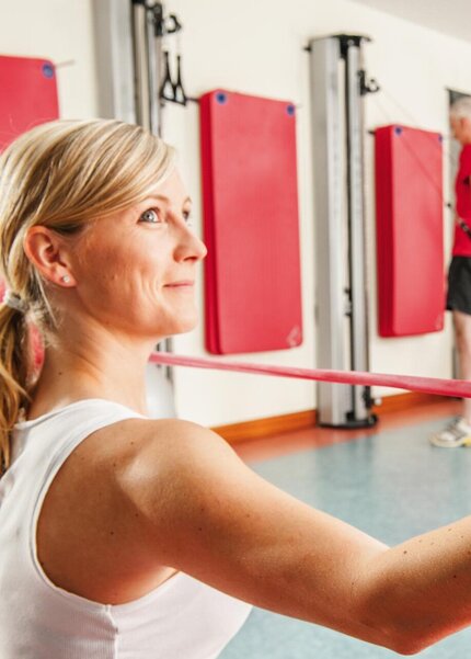 Frau bei Sportübungen mit Theraband