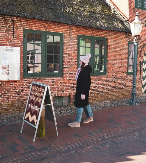 Museum Landschaft Eiderstedt mit Besucherin vor der Tür