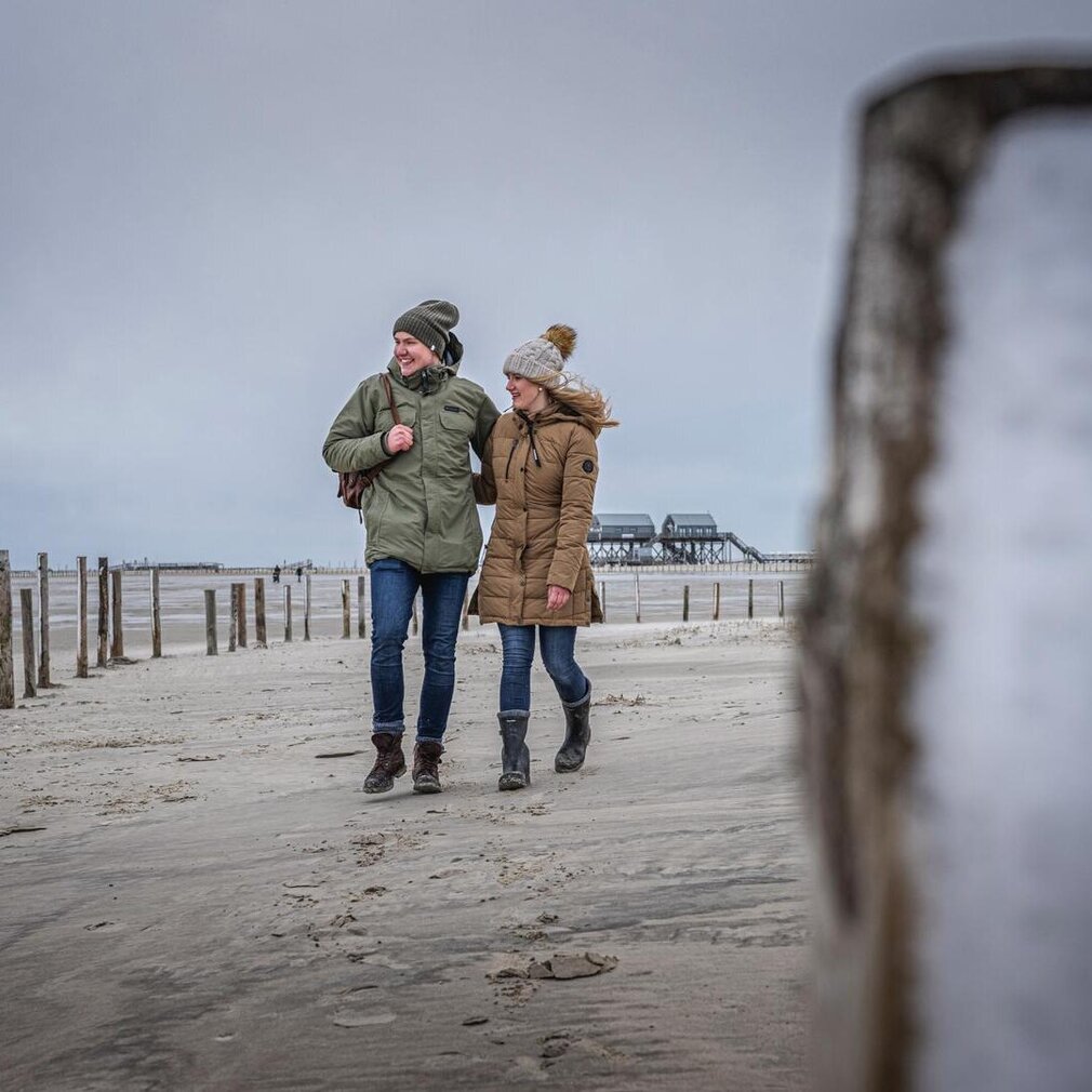 junges Paar spaziert am Winterstrand