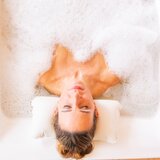 Frau mit Schaum in Badewanne