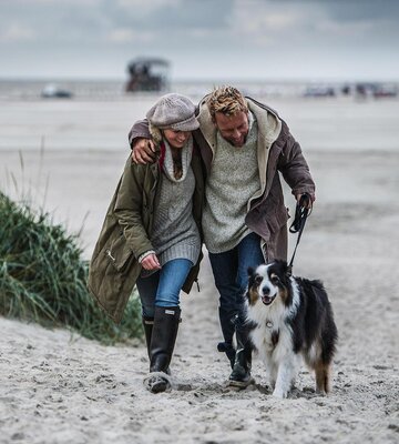 Pärchen mit Hund am Hundestrand