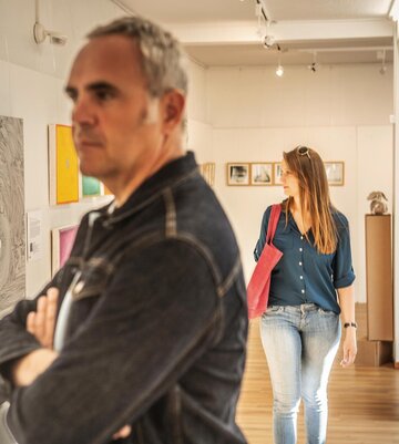 Besucher schauen Bilder in einer Galerie an