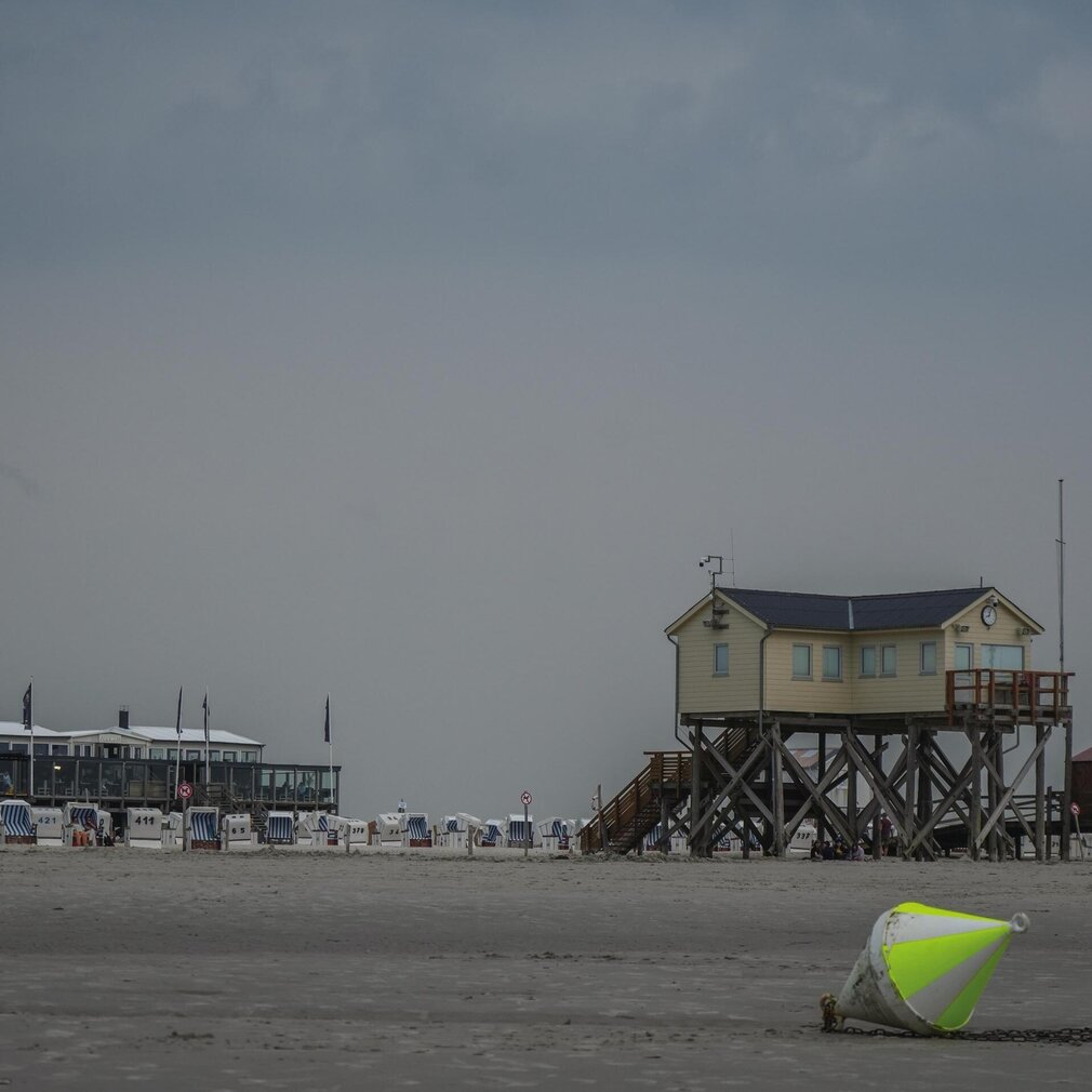 Ein Pfahlbau am Strand von SPO – im Vordergrund liegt eine Boje