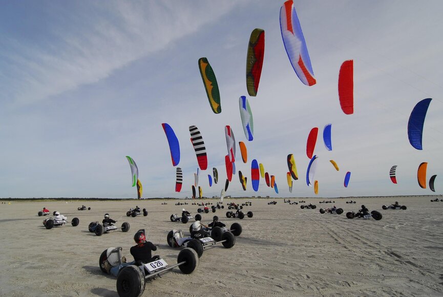 große Gruppe von Kitebuggy-Fahrern am Strand