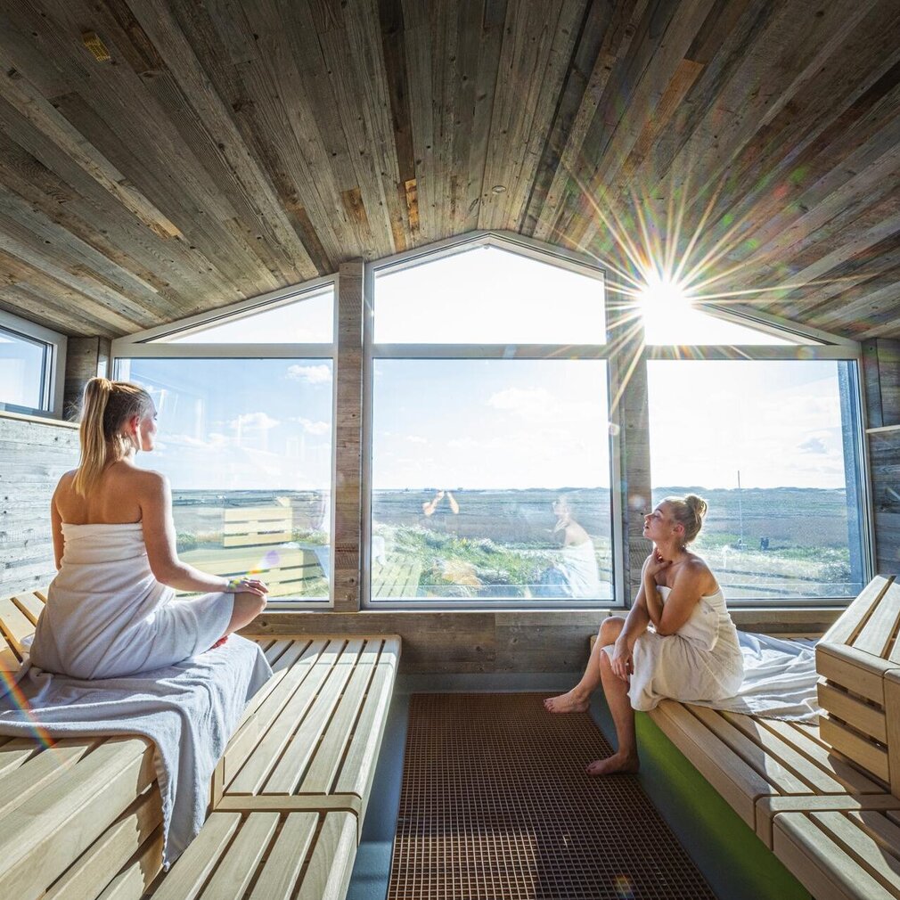 2 Freundinnen blicken aus der Pfahlbausauna