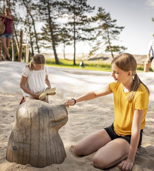 Zwei Mädchen spielen an einem Themenspielplatz