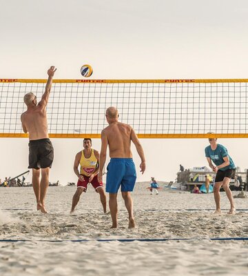 junge Männer spielen Volleyball am Strand