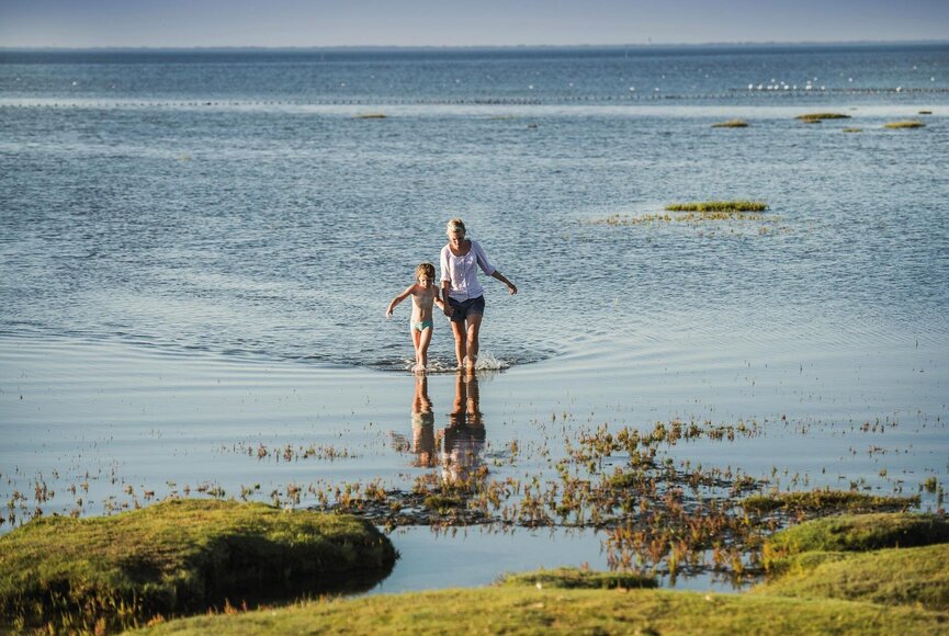 Spaziergang von Mutter und Kind im Wasser der Badestelle Stufhusen
