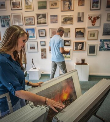 Besucher in einer Galerie schauen sich Bilder an