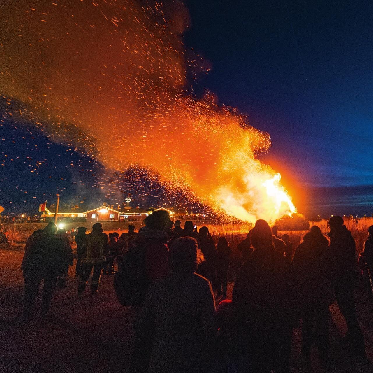 großes Biikefeuer mit Zuschauern am Abend