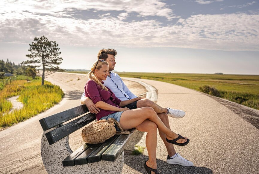 Pärchen auf einer Bank auf dem Deich