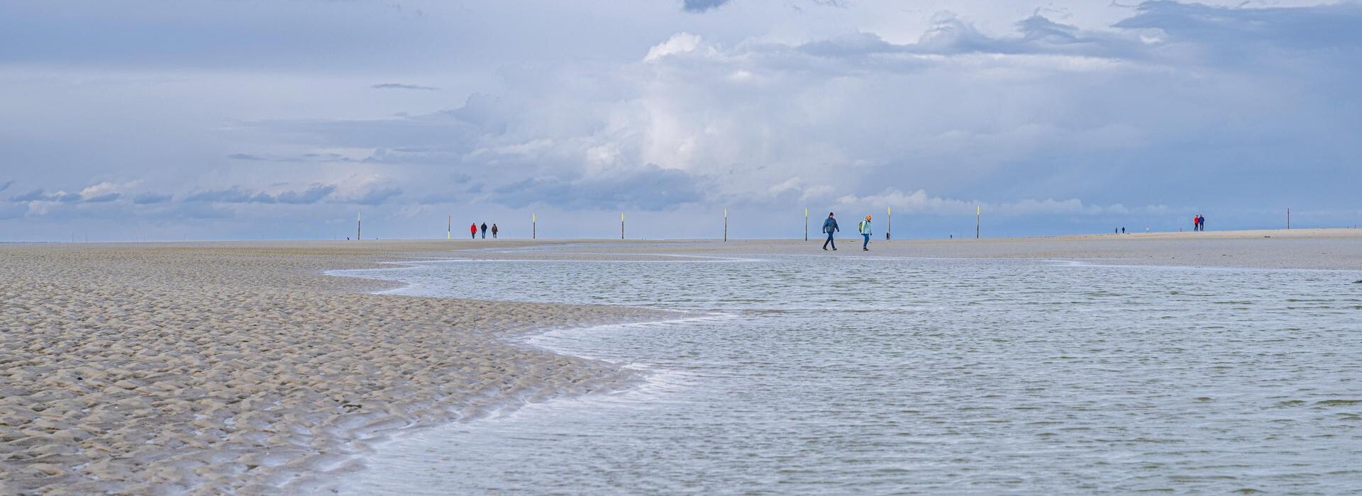 Spaziergänger in den Wellen am Strand
