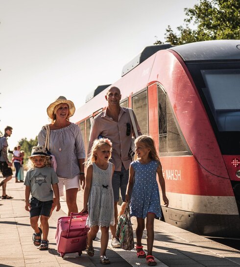 Familie mit Gepäck bei der Ankunft am Bahnsteig in St. Peter-Ording