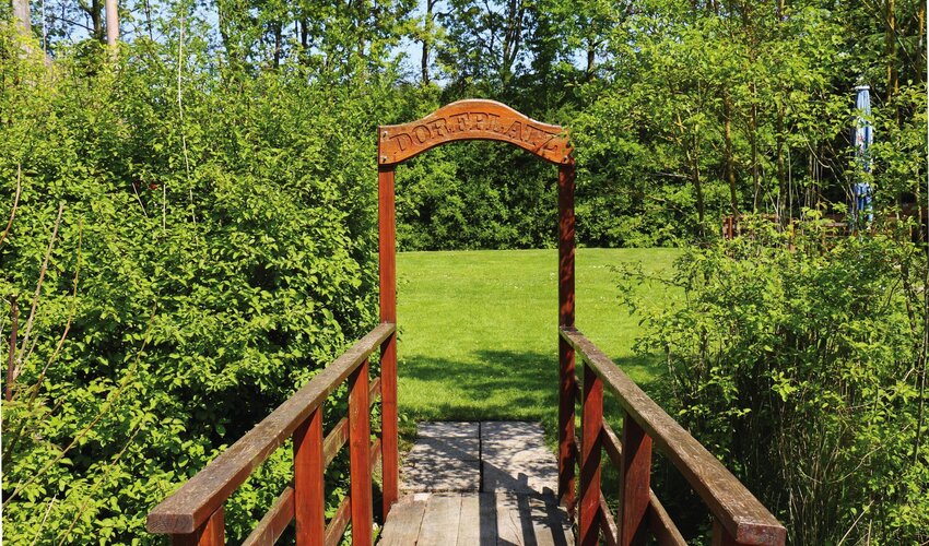 kleine hölzerne Brücke führt zum Dorfplatz