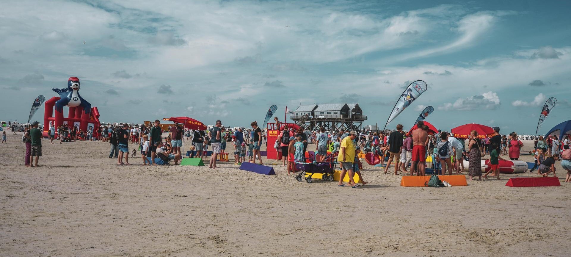 Strandfest mit Pfahlbau im Hintergrund
