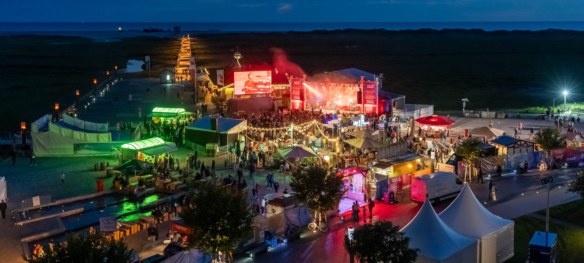 Das gesamte HÆDI-Festivalgelände strahlt bei Nacht mit bunten Lichtern und stimmungsvoller Beleuchtung
