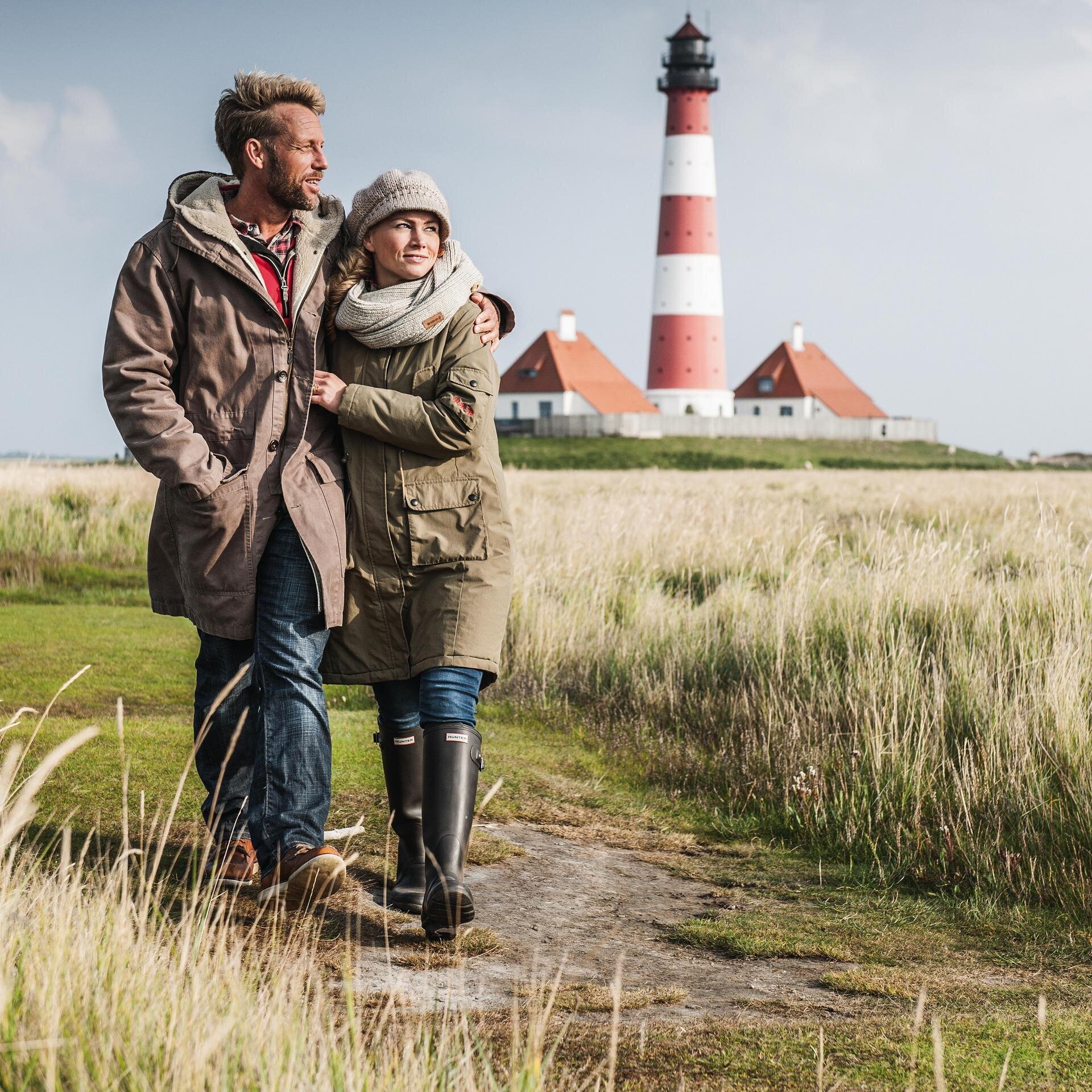 Paar spaziert im Herbst beim Westerhever Leuchtturm
