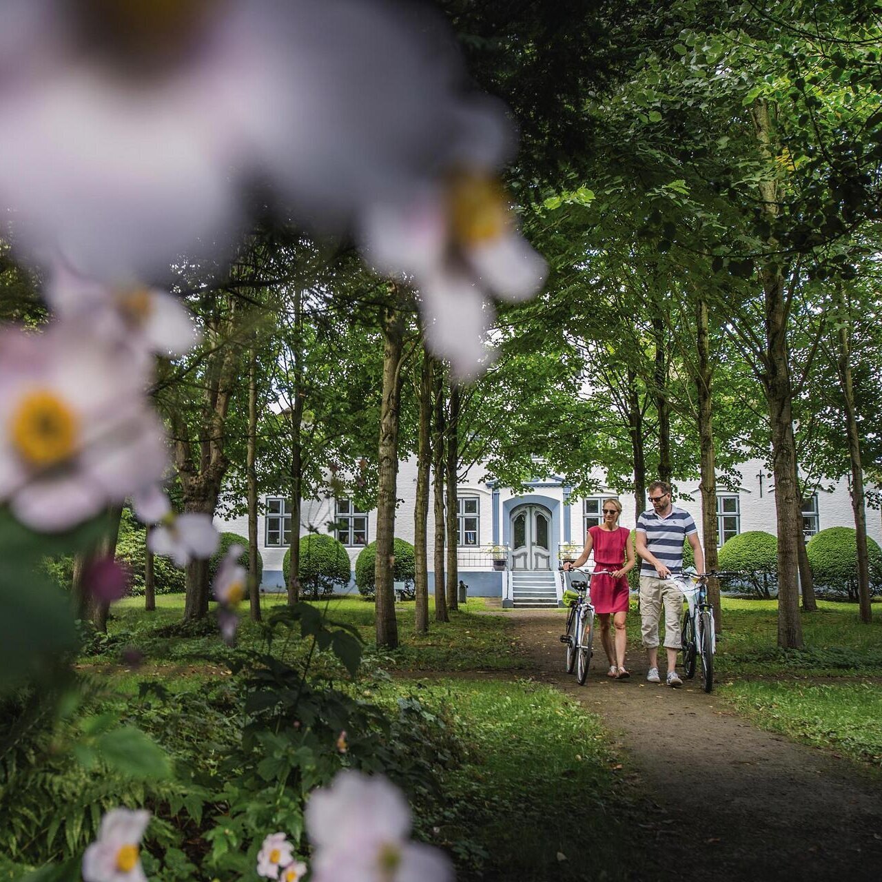 Paar mit Rädern im blumigen Hochdorfer Garten