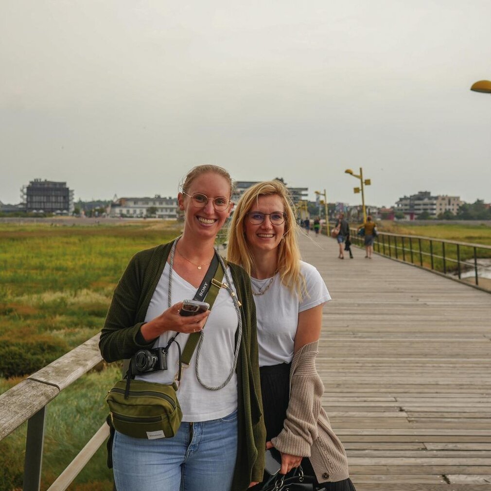 Zwei Mitarbeiterinnen von der Tourismus-Zentrale St. Peter-Ording lächeln in die Kamera