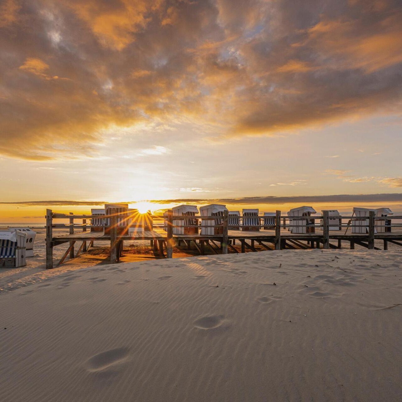Strandkörbe auf dem Podest im Sonnenuntergang