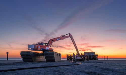 Abriss mit Bagger bei der Strandbar 54 Grad im Abendlicht