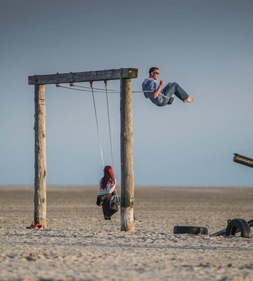 A couple on a swing at the beach