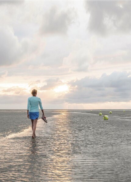 Frau beim Strandspaziergang in der Abendsonne