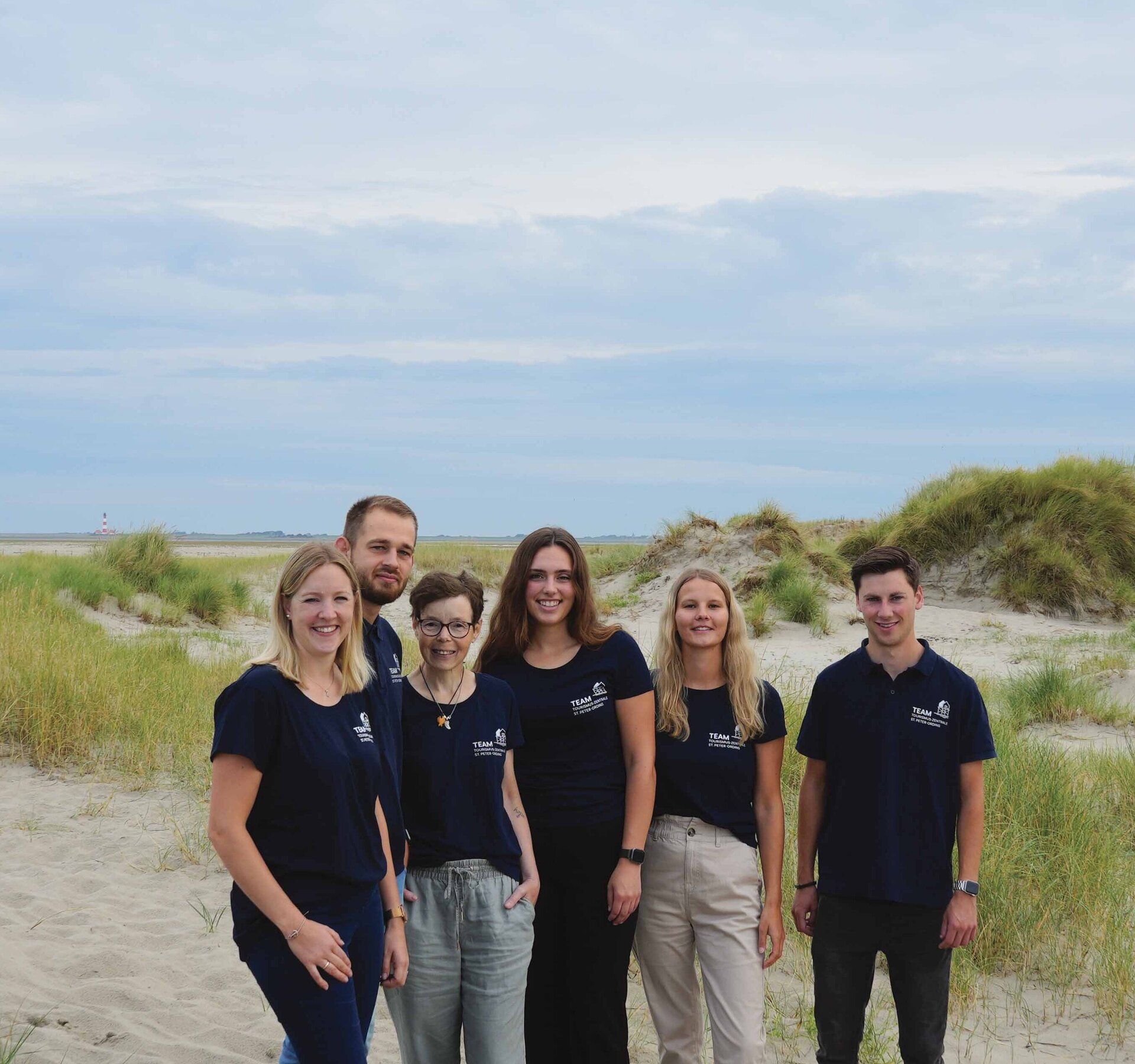 Grupenfoto von Tourist-Info-Mitarbeitern am Strand in den Dünen